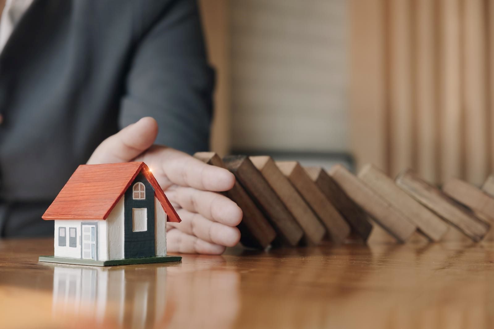 Toy house symbolizing protection, featuring 411 Immigration Law and highlighting 'Groups at Risk of Persecution' to emphasize legal support for vulnerable individuals.