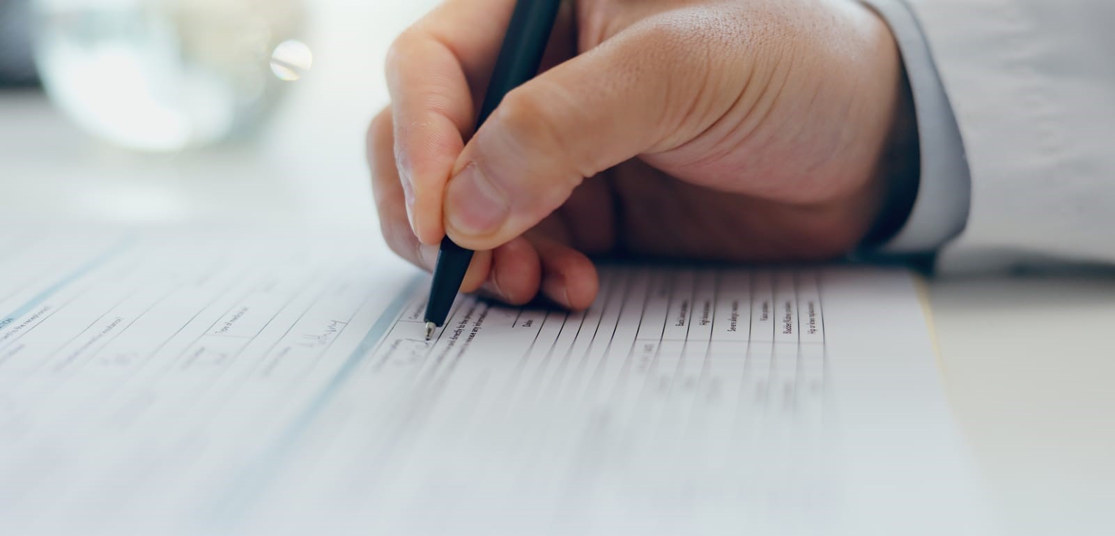 Image of a person signing documents, symbolizing the beginning of the asylum process. Text overlay features '411 Immigration Law' and 'Initial Steps in Filing for Asylum,' emphasizing guidance in starting asylum applications.