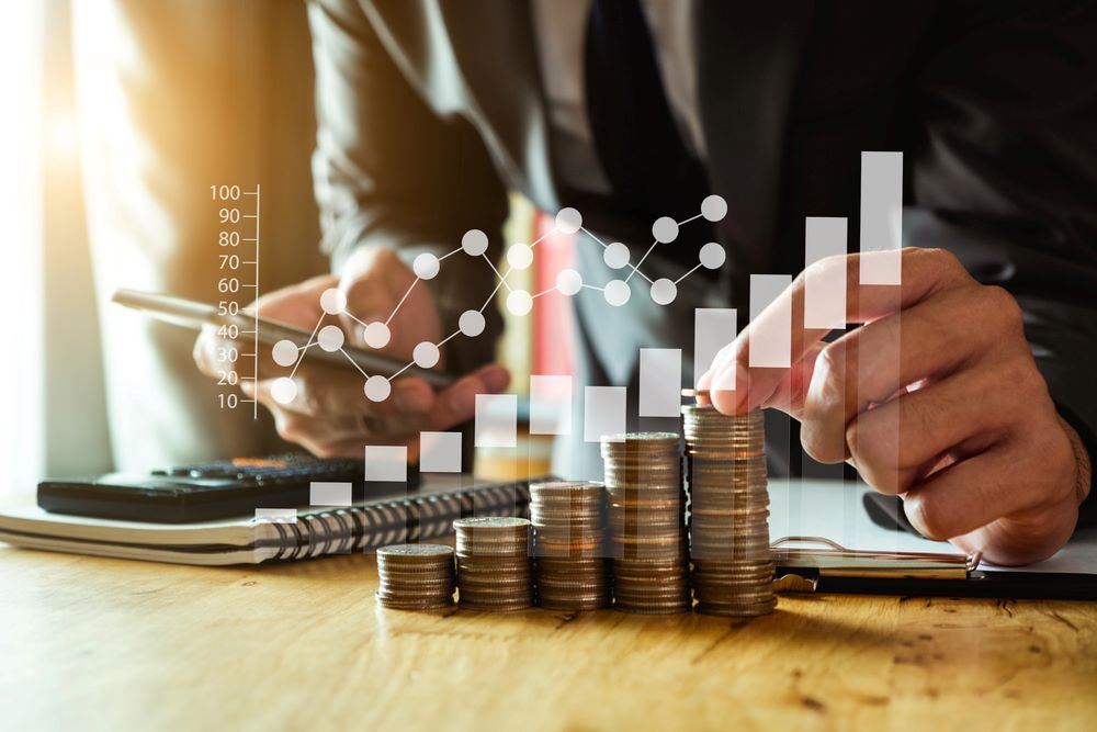 Image of a businessman holding coins and placing them into a glass jar while using a smartphone, featuring 411 Immigration Law and highlighting Proof of Financial Support, ensuring it aligns with the page's context.